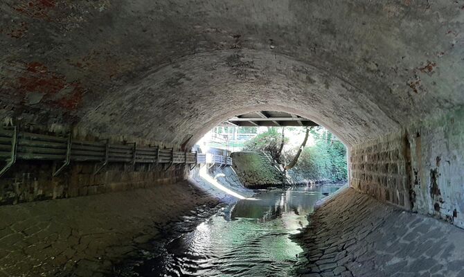 Unter der Gewölbebrücke fließt ein Gewässer hindurch.