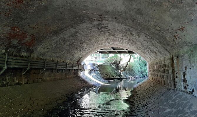 Unter der Gewölbebrücke fließt ein Gewässer hindurch.