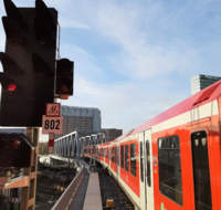 Eine rote Hamburger S-Bahn überquert die neue Eisenbahnüberführung Berliner Tor